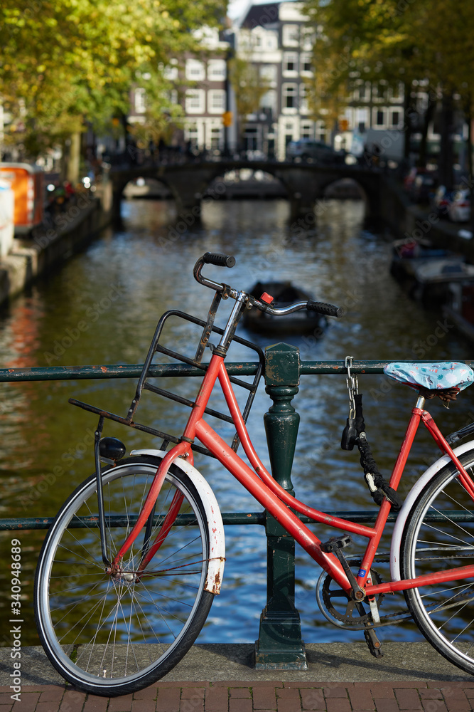 A bicycle parked on a bridge over an Amsterdam canal