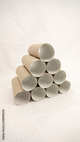 Cardboard tubes of a roll of toilet paper stands in a triangle. Panic buying has caused a shortage around the world. During this coronavirus pandemic we are seeing shops empty