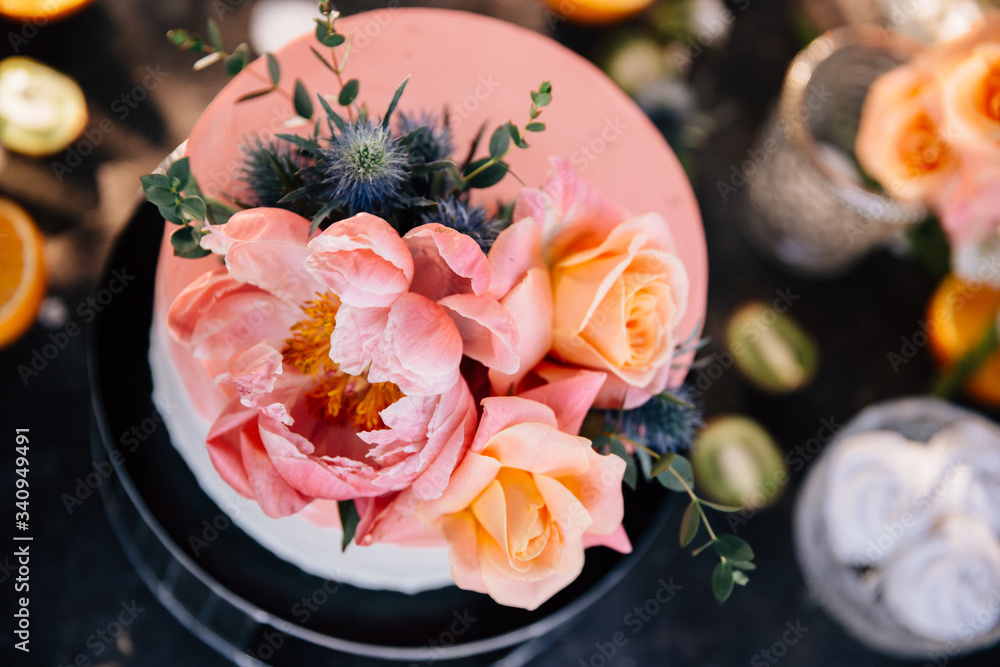 Fototapeta premium wedding cake in coral decorated with fresh flowers