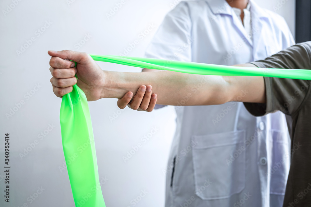 Female Physiotherapist working examining treating injured arm of athlete male patient, stretching and exercise, Doing the Rehabilitation therapy pain in clinic