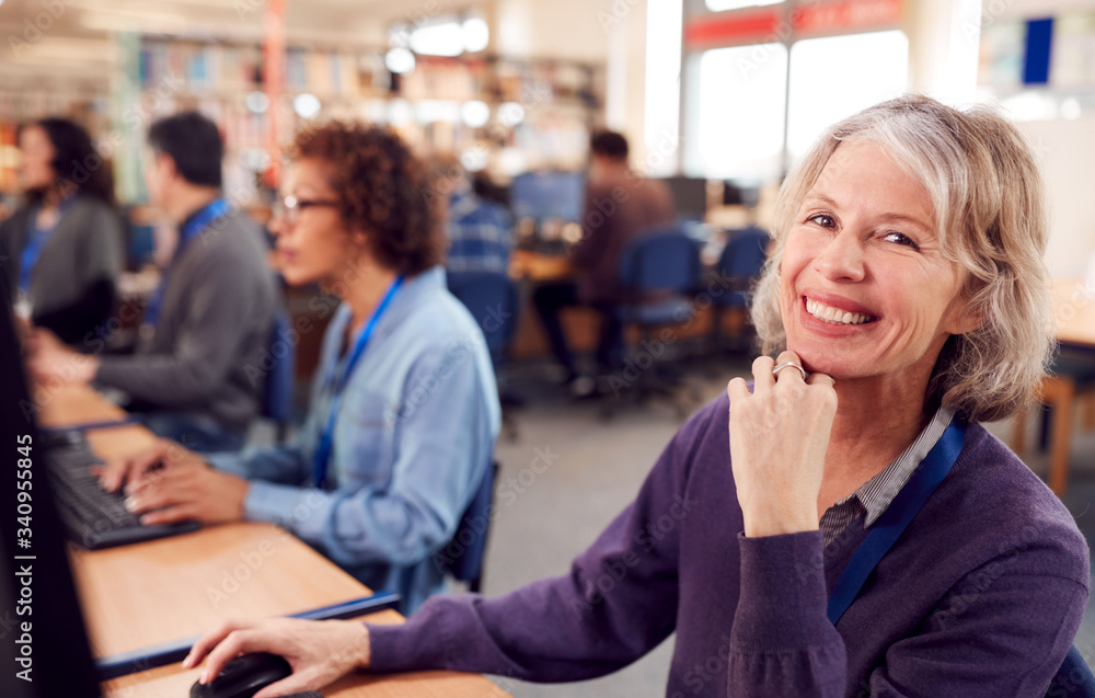 Portrait Of Female Mature Adult Student In Class Working At Computers In College Library Portrait Of Female Mature Adult Student In Class Working At Computers In College Library