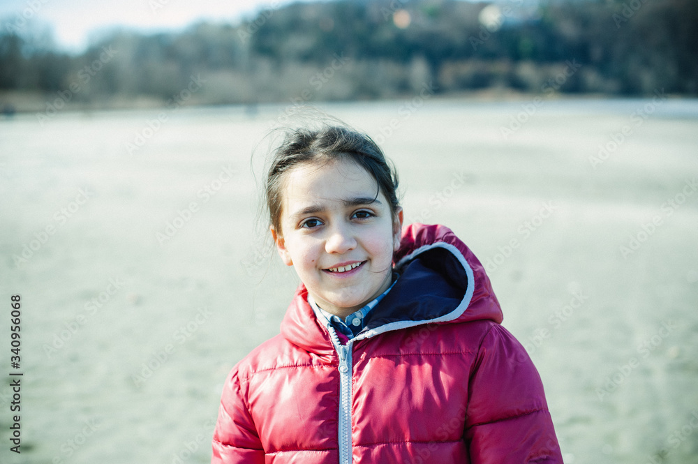 portrait of smiling little girl backlit in the open air in winter portrait of smiling little girl backlit in the open air in winter