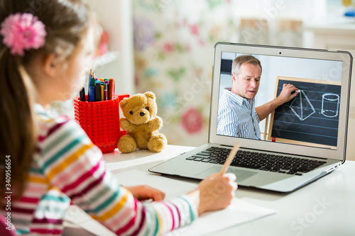 Φωτογραφία Middle-aged distance teacher having video conference call with pupil using webcam