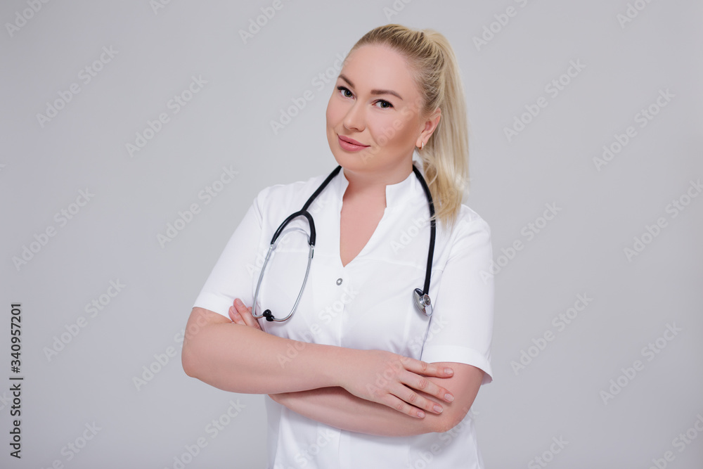 portrait of young female doctor posing over gray portrait of young female doctor posing over gray
