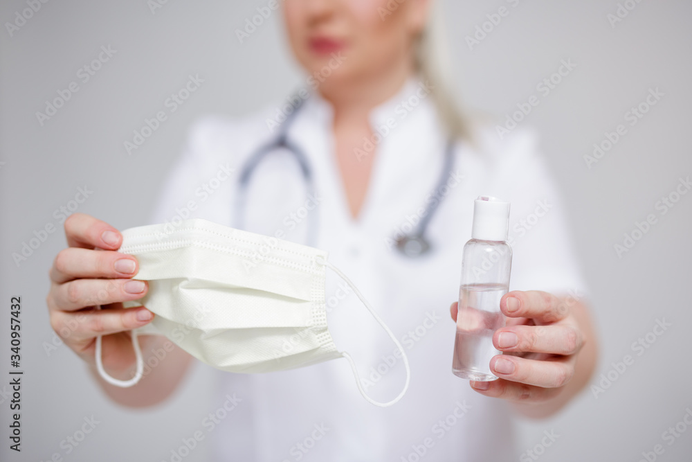 Fototapeta premium health care and corona virus pandemic concept - doctor or nurse holding sanitizer and protective mask