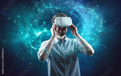 Junger Mann schaut durch VR-Brille und taucht in virtuelle Welt ein