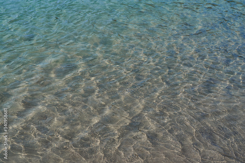 River sand beach. The texture of clear water of Altai river.