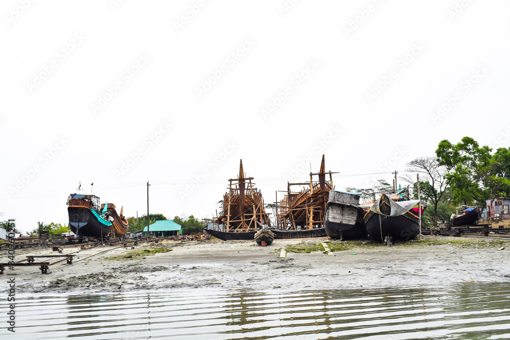 Picture of a harbor of different sized wooden fishing boat,where the boats are grounded safely