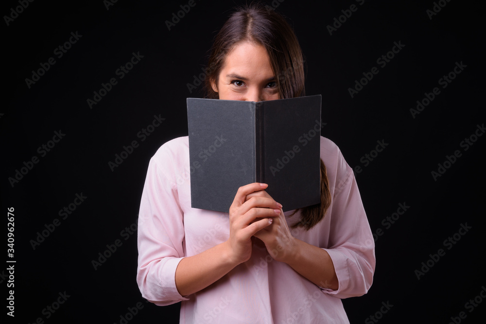 Young multi ethnic beautiful businesswoman against black background Young multi ethnic beautiful businesswoman against black background