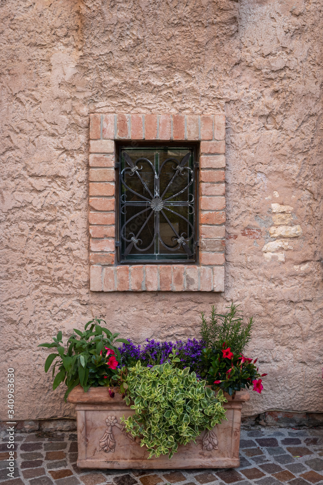 detail of a flower pot located near a window of an ancient house