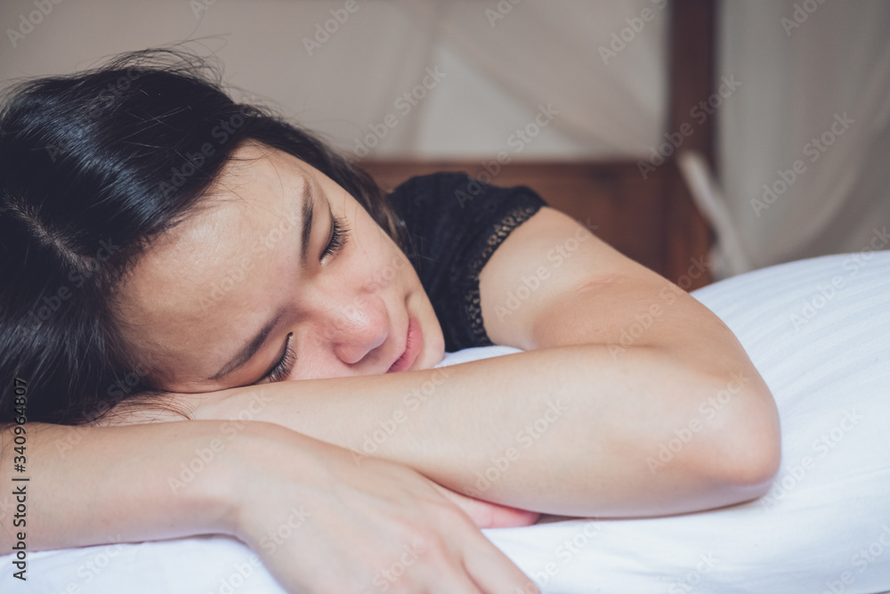 Optimistic thoughtful Asian woman with closed eyes lying on comfortable bed in morning at home Optimistic thoughtful Asian woman with closed eyes lying on comfortable bed in morning at home