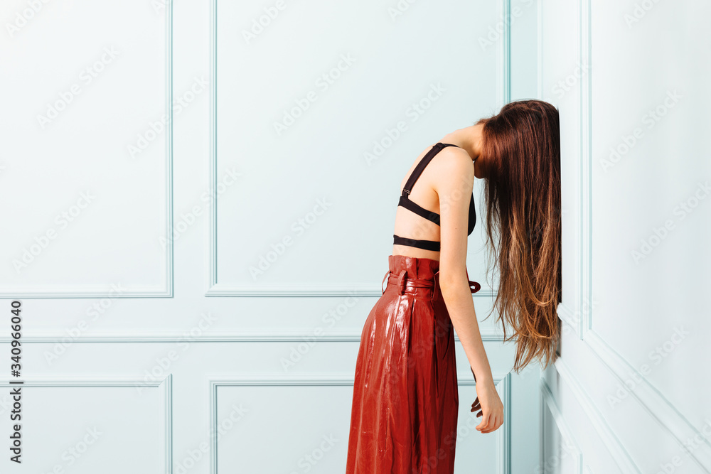 Side view of woman leaning on wall