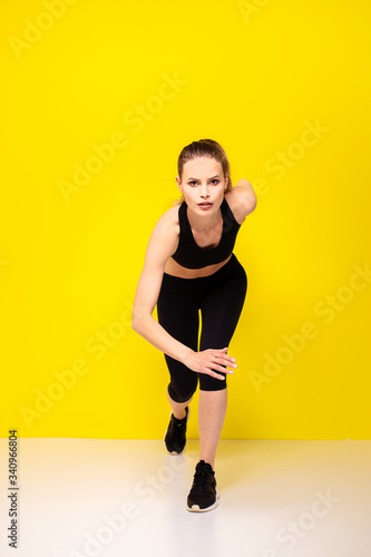 young woman doing exercise on yellow background © All king of people