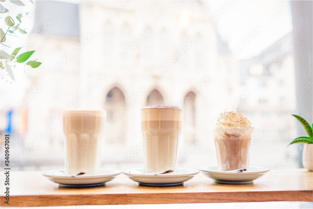 Three glasses of coffee drinks. Coffee latte, latte with chocolate and coffee mocha near the window Three glasses of coffee drinks. Coffee latte, latte with chocolate and coffee mocha near the window