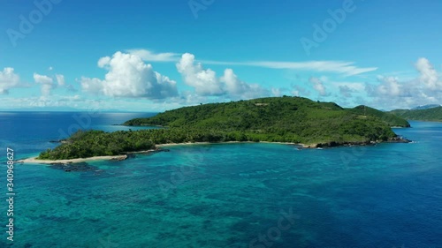 Tropical green island with clouds in the background