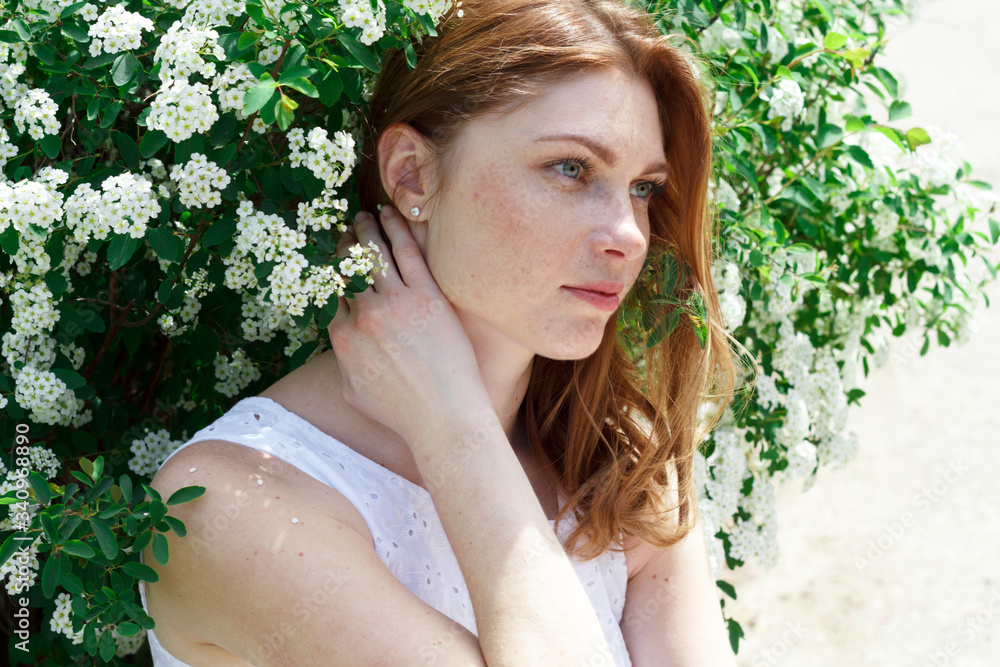 beautiful red-haired woman with freckles surrounded by white flowers beautiful red-haired woman with freckles surrounded by white flowers