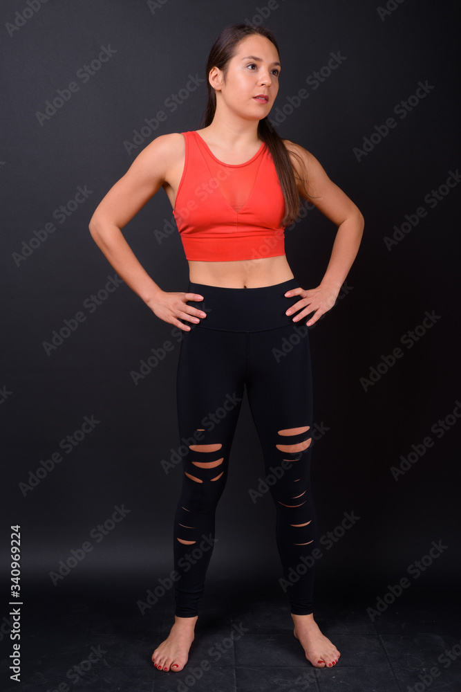 Young multi ethnic beautiful woman ready for gym against black background Young multi ethnic beautiful woman ready for gym against black background