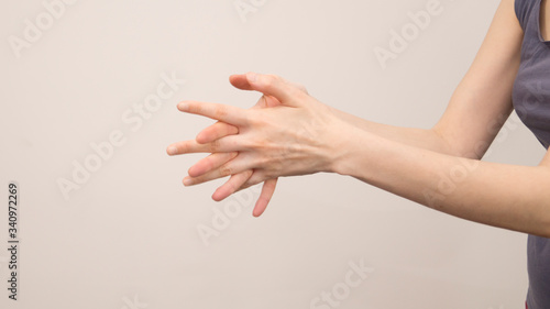Close-up of female hands holding her painful wrist caused by prolonged work on a computer, laptop. Carpal tunnel syndrome, arthritis, neurological disease.
