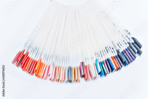 fan with multicolored nail samples on a light background in a nail salon, copy space