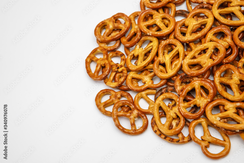 Salty cracker cookies in the shape of a pretzel sprinkled on a white background.Close-up. Texture Oktoberfest symbol Salty cracker cookies in the shape of a pretzel sprinkled on a white background.Close-up. Texture Oktoberfest symbol