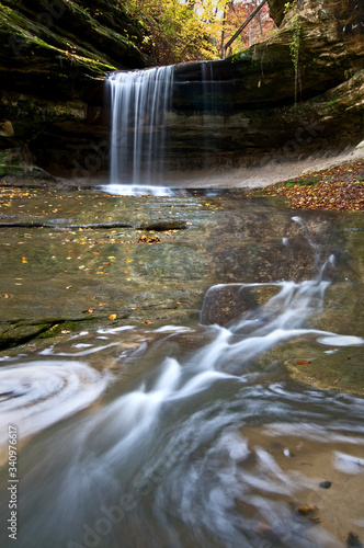 A waterfall flowing through a sandstone canyon.