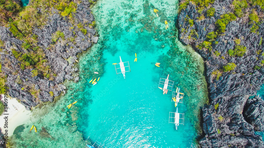 Kayaks and boats in small lagoon. El Nido, Palawan, Philippines. Aerial view. 