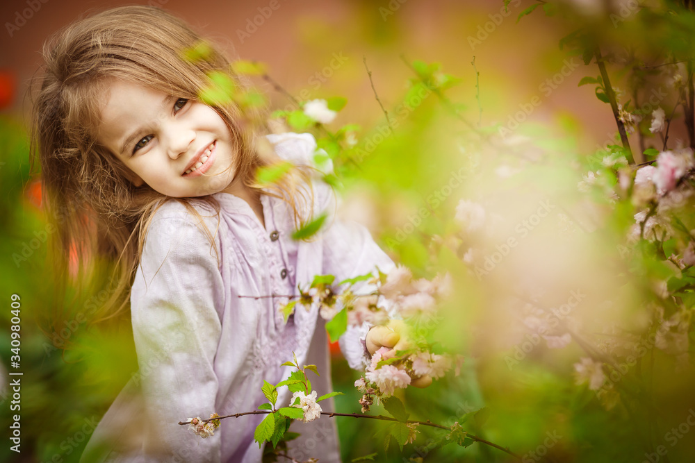small girl in garden with pink almond bush