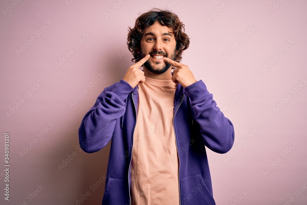 Young handsome sporty man with beard wearing casual sweatshirt over pink background Smiling with open mouth, fingers pointing and forcing cheerful smile Young handsome sporty man with beard wearing casual sweatshirt over pink background Smiling with open mouth, fingers pointing and forcing cheerful smile