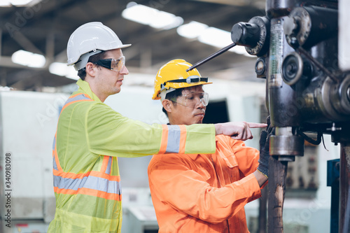 Worker in industrial factory discussing install replacement machine
