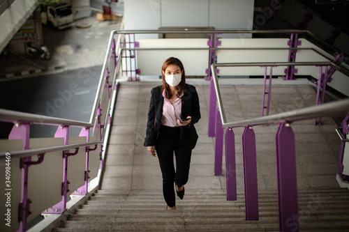 Woman wearing mask waking to work.