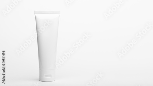 Plastic unbranded flacon. Tube for cream  body lotion  toiletry. Container for professional care products. Skincare and beauty concept. Mockup  copy space in left side. Isolated on white