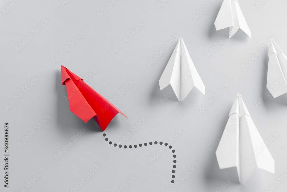 Red paper plane as a leader. White planes follow him. White background. Change of course Red paper plane as a leader. White planes follow him. White background. Change of course