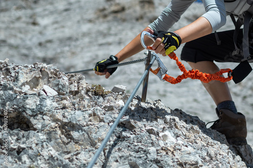 Climbing along a steel line on the via ferrata route in the dolomites