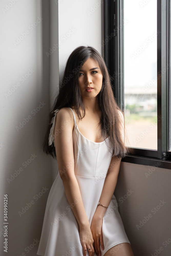Beautiful sexy asian woman black long hair wearing seductive white lingerie posing in bedroom. Portrait of asia women at home in morning time. beauty and fashion people indoor concept. Beautiful sexy asian woman black long hair wearing seductive white lingerie posing in bedroom. Portrait of asia women at home in morning time. beauty and fashion people indoor concept.
