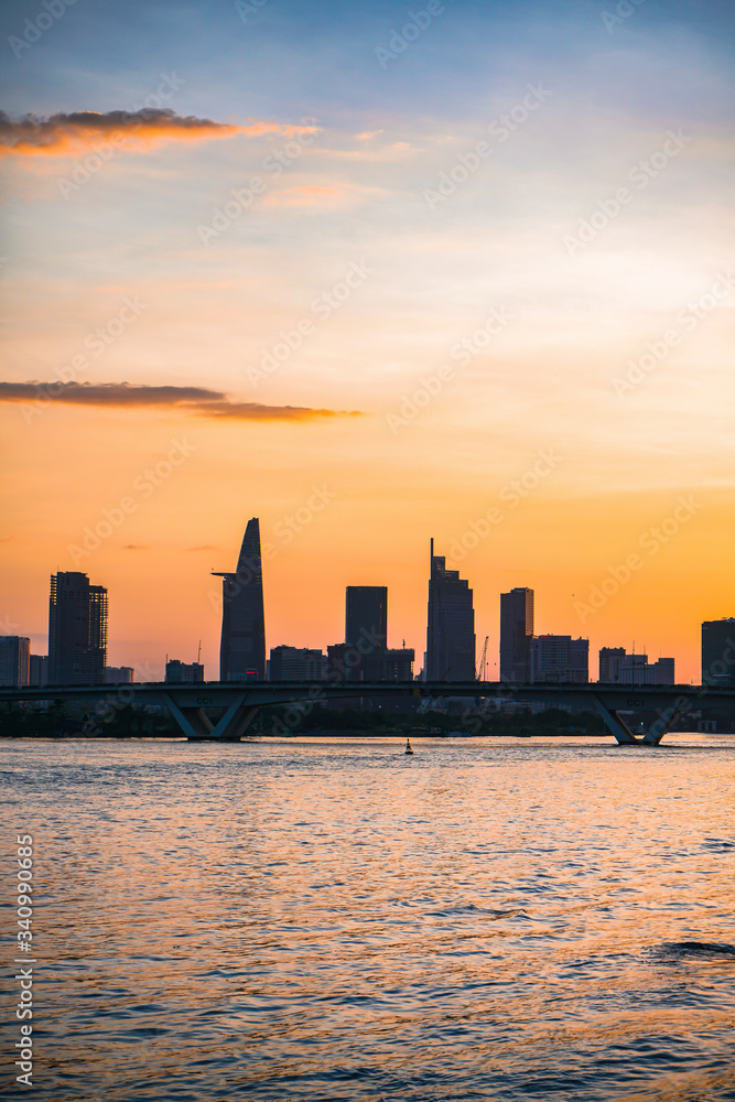 River city view landscape at twilight sunset. Boat on river with tranquil water. Hochiminh city Saigon vietnam cityscape building with Bitexco tower