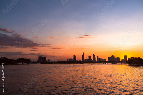 River city view landscape at twilight sunset. Boat on river with tranquil water. Hochiminh city Saigon vietnam cityscape building with Bitexco tower