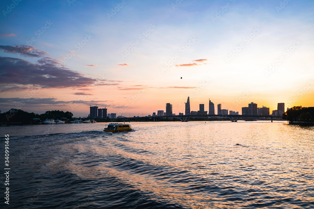 River city view landscape at twilight sunset. Boat on river with tranquil water. Hochiminh city Saigon vietnam cityscape building with Bitexco tower