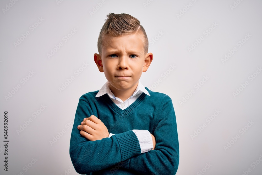 Young little caucasian kid with blue eyes standing wearing elegant clothes over isolated background skeptic and nervous, disapproving expression on face with crossed arms. Negative person. Young little caucasian kid with blue eyes standing wearing elegant clothes over isolated background skeptic and nervous, disapproving expression on face with crossed arms. Negative person.