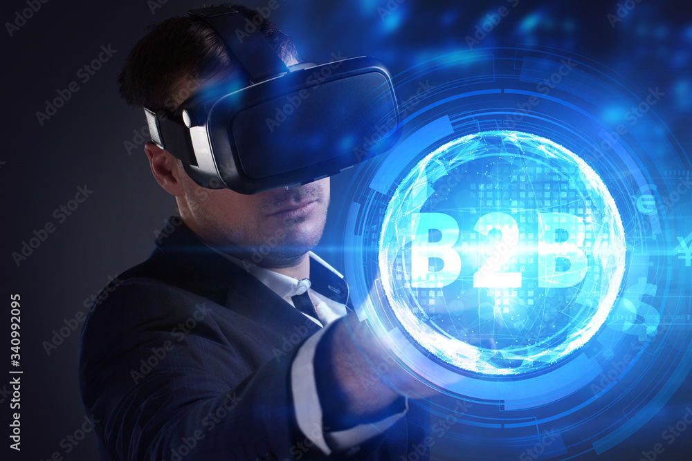 Business, Technology, Internet and network concept. Young businessman working on a virtual screen of the future and sees the inscription: B2B Business, Technology, Internet and network concept. Young businessman working on a virtual screen of the future and sees the inscription: B2B