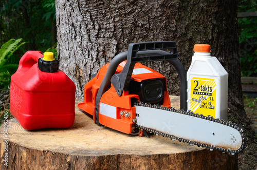 chainsaw with canister of gasoline and motor oil