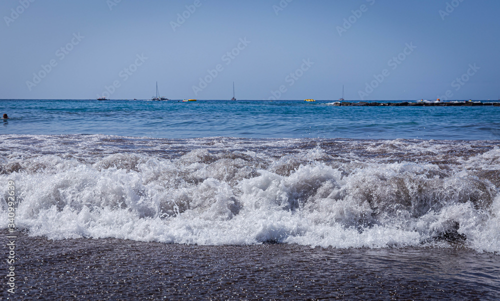 Ocean waves roll ashore on the beach