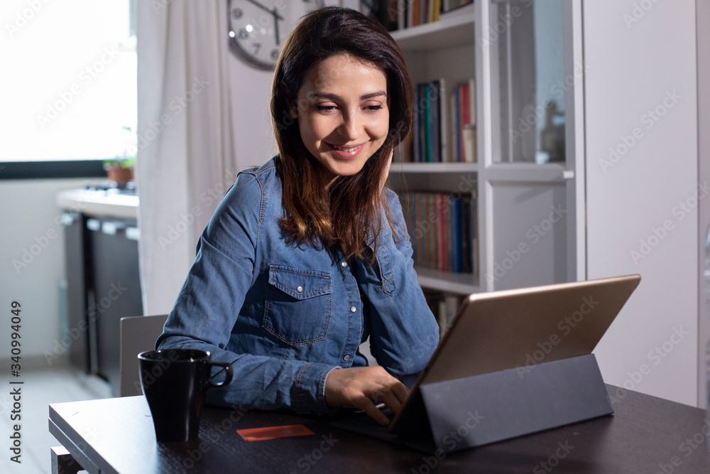 Φωτογραφία Giovane donna  fa un ordine con la carta di credito seduta di fronte al suo iPad