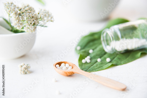 homeopathic granules, medicinal herbs on a natural wooden table on a natural background. alternative medicine and homeopathy photo