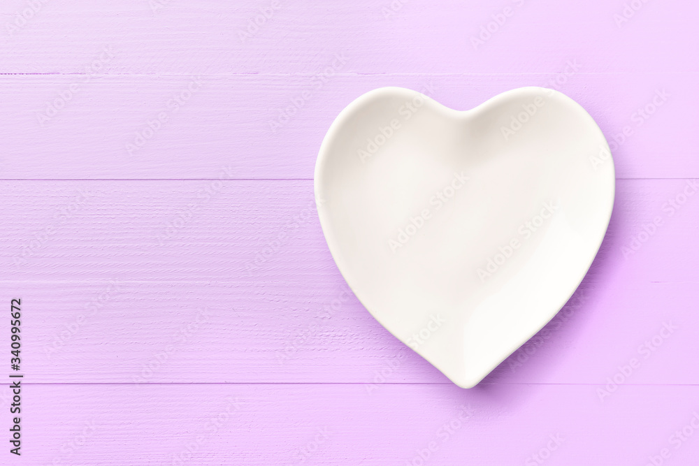 Empty white heart-shaped plate on a pink bright wooden plank background. Abstract template for holiday valentines day. Close-up. Love concept Empty white heart-shaped plate on a pink bright wooden plank background. Abstract template for holiday valentines day. Close-up. Love concept