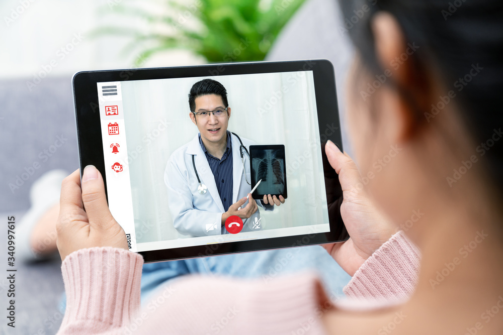 Asian chinese doctor video conference call online live talk follow up remotely in medical coronavirus result with asia woman sit at sofa couch at home. Online healthcare digital tech service concept.