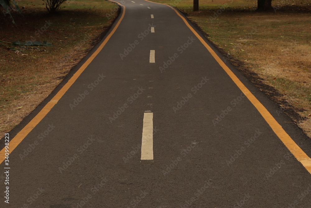 asphalt road with yellow lines