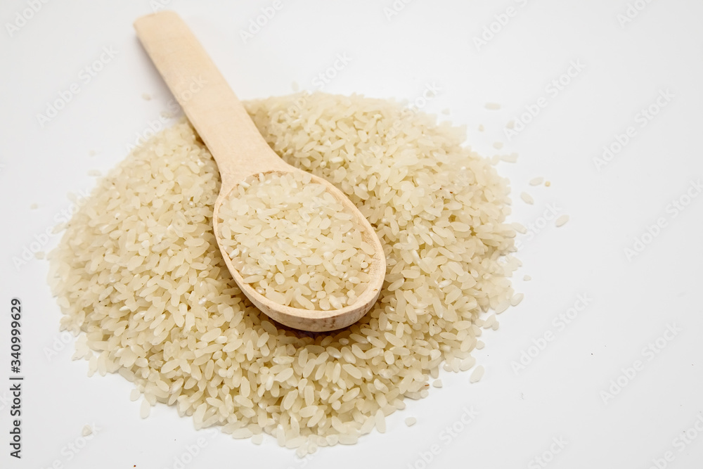 Grits rice in a wooden spoon, background. Rice background Grits rice in a wooden spoon, background. Rice background