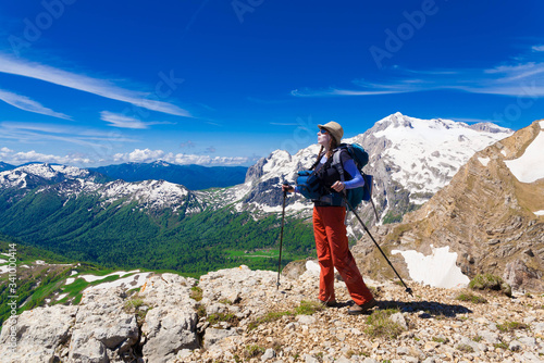 A woman in mountain day summer. Rocky route. Blue sky. Snow and glacier