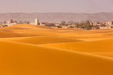 View of Merzouga town in background in Desert Sahara with beautiful lines and colors at sunrise. Merzouga, Morocco