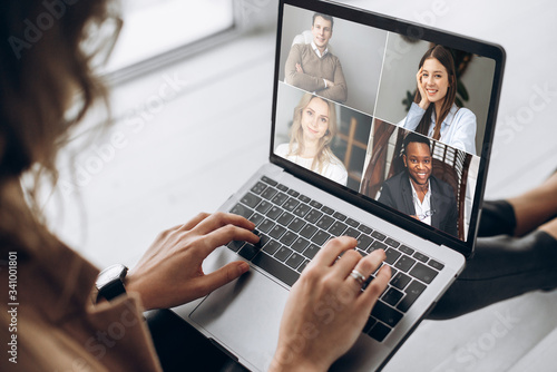 Online business meeting. Business team working from home in a video conference. .The girl communicates via video call communication using laptop with her business colleagues about the future strategy © Kateryna